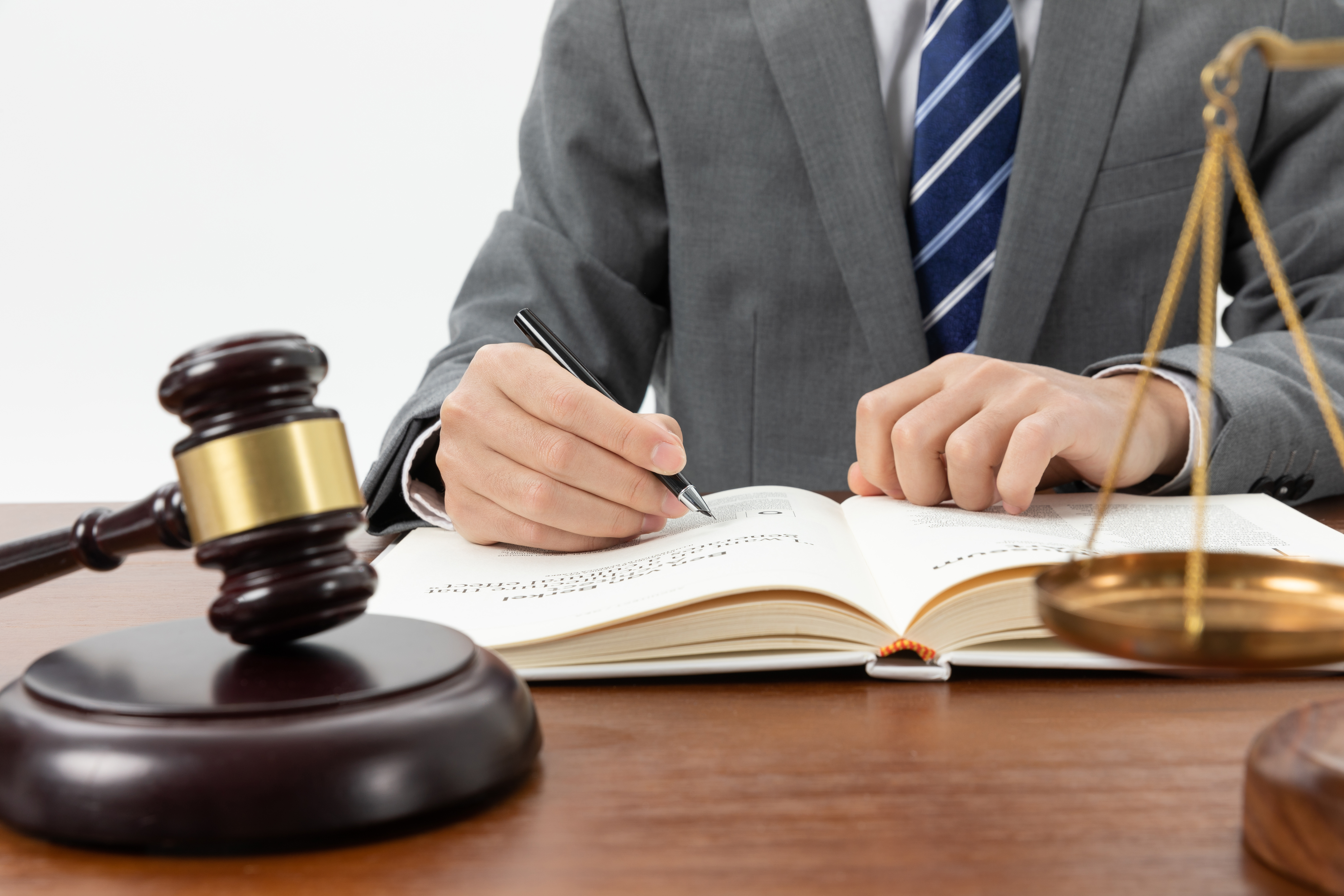 closeup-shot-person-writing-book-with-gavel-table (1).jpg